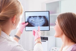 dentist shows patient digital dental radiographs